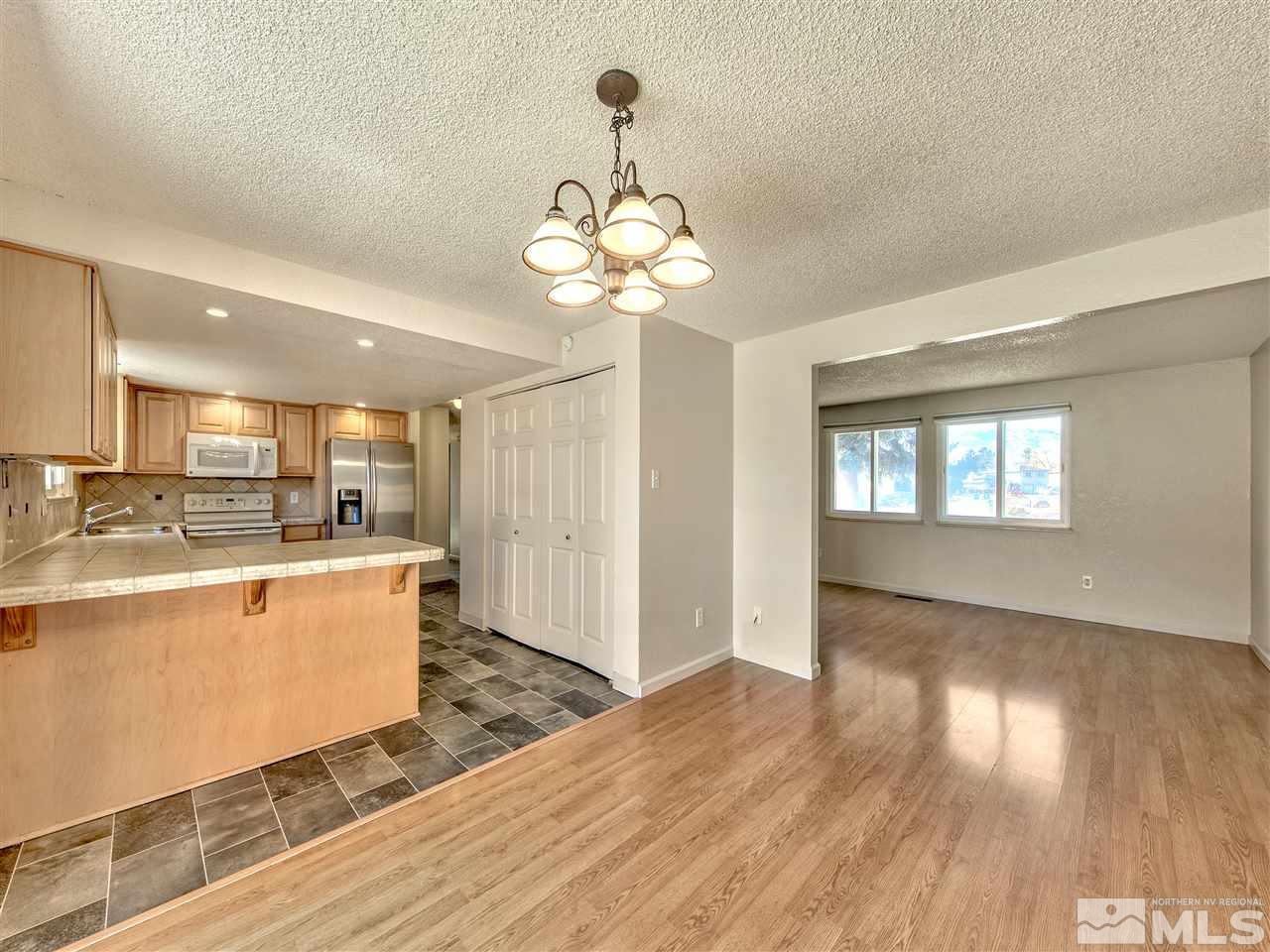 7460 Berryhill Drive Reno, NV 89511 - Photo 10 of 23 a open kitchen with stainless steel appliances granite countertop a refrigerator a sink dishwasher a stove and white countertops with wooden floor