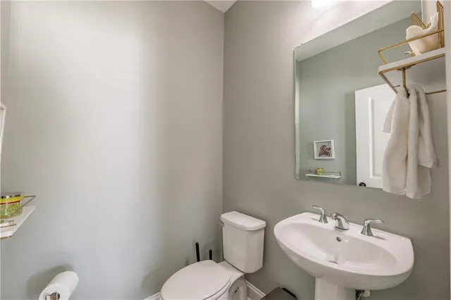 a bathroom with a sink a toilet and a mirror