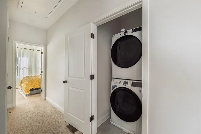 a utility room with dryer washer and a view of bedroom