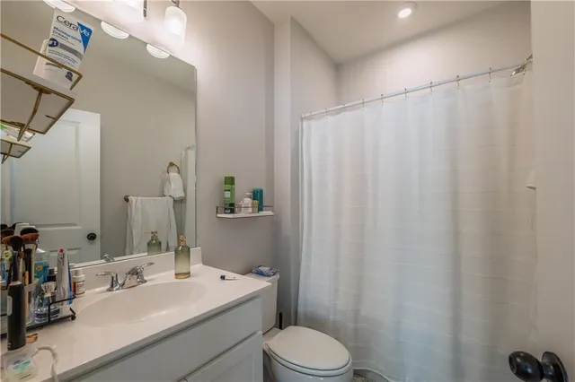 a bathroom with a sink a toilet and shower curtain