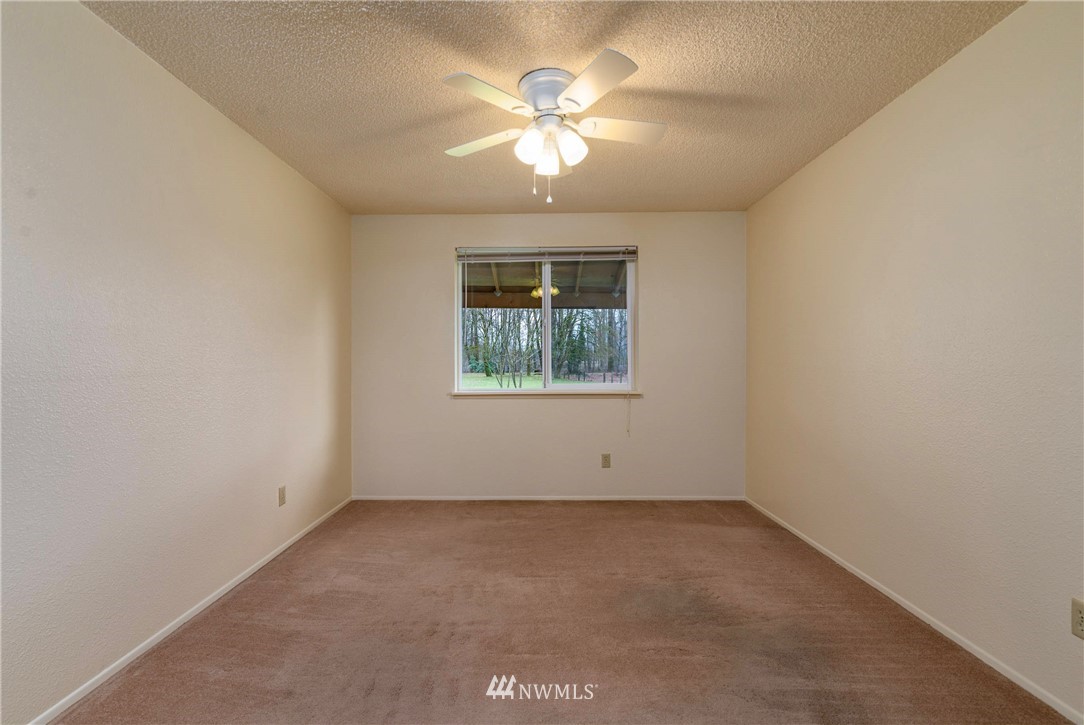 7456 Riverside Drive East Sumner, WA 98390 - Photo 11 of 40 an empty room with a window and a ceiling fan