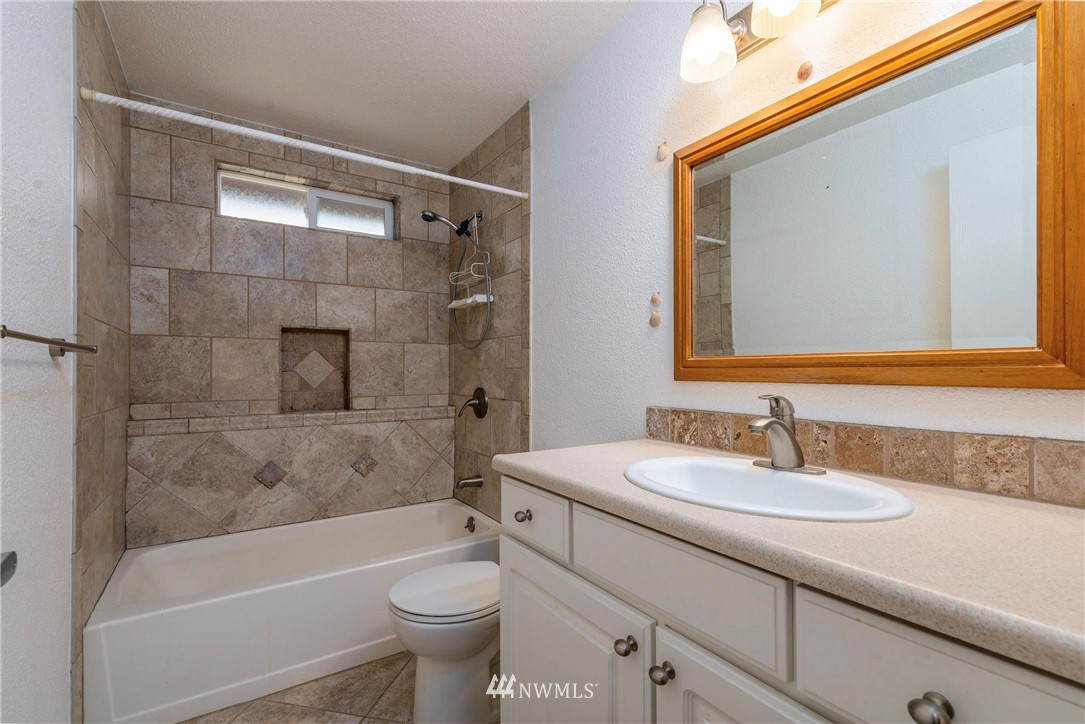 7456 Riverside Drive East Sumner, WA 98390 - Photo 19 of 40 a bathroom with a sink mirror toilet and bathtub
