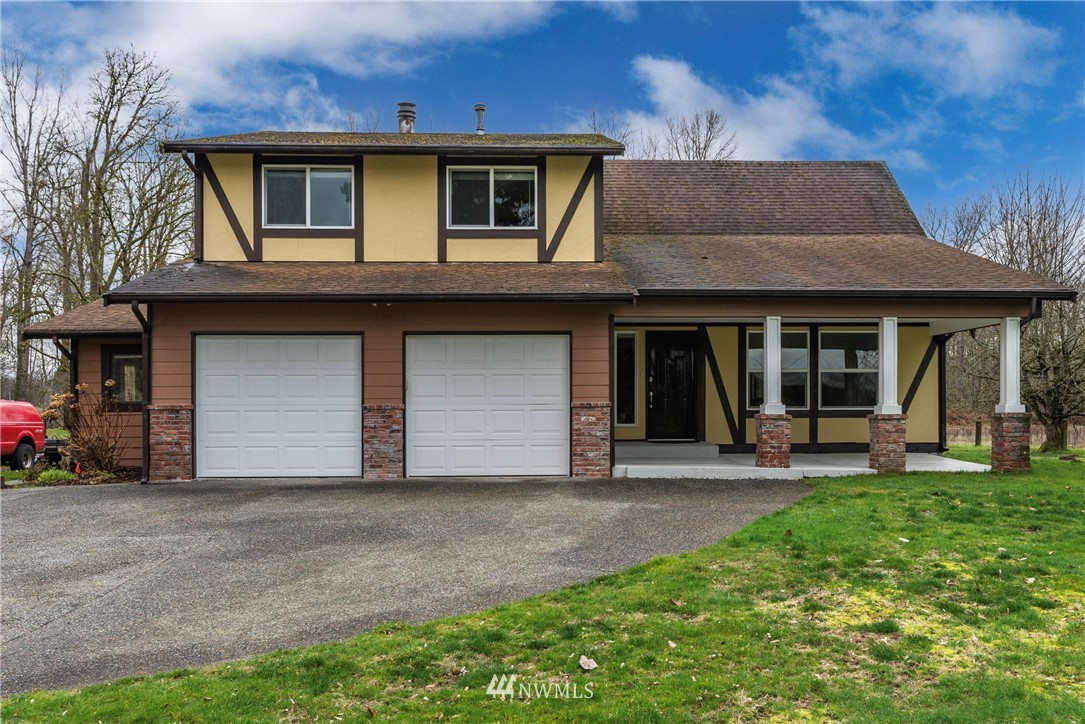 7456 Riverside Drive East Sumner, WA 98390 - Photo 4 of 40 a front view of a house with a yard and garage