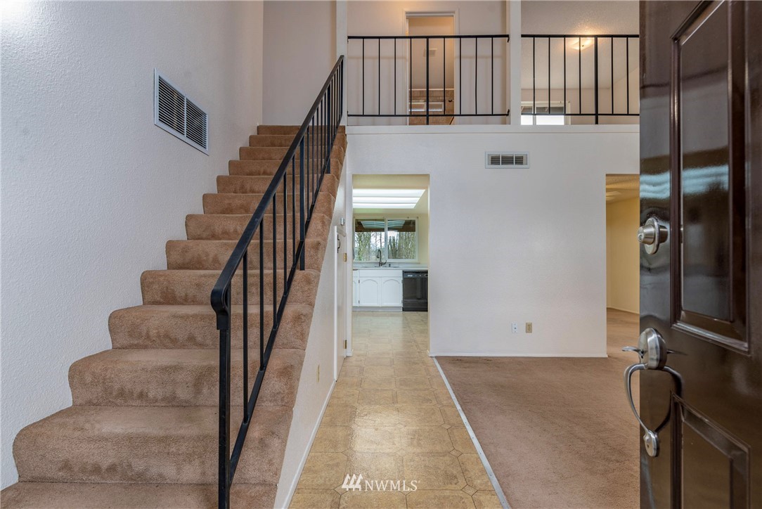 7456 Riverside Drive East Sumner, WA 98390 - Photo 7 of 40 a view of staircase with lots of frames on wall and a chandelier