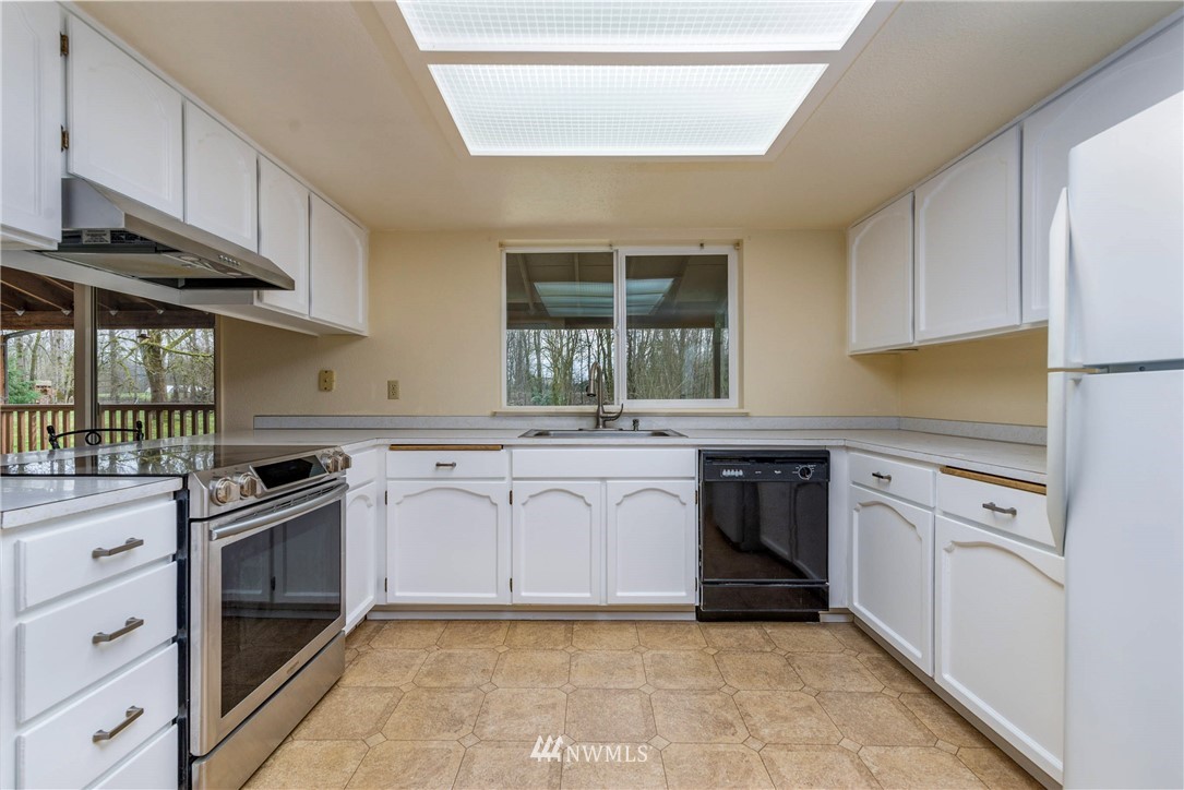 7456 Riverside Drive East Sumner, WA 98390 - Photo 10 of 40 a kitchen with white cabinets appliances and a window