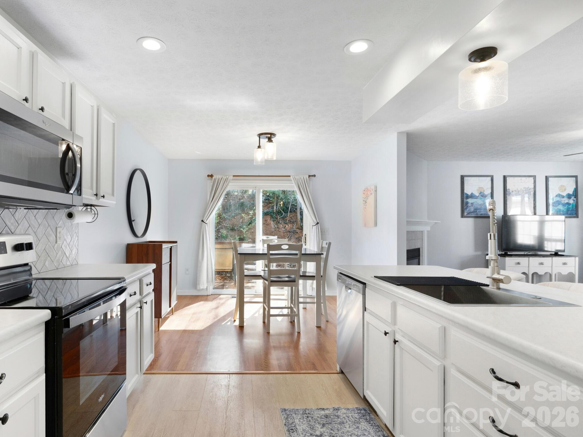 1 Mosers Place Candler, NC 28715 - Photo 13 of 32 a kitchen with granite countertop a stove a sink a dining table and chair with wooden floor