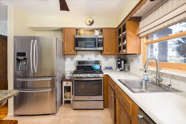 a kitchen with stainless steel appliances granite countertop a sink stove and refrigerator