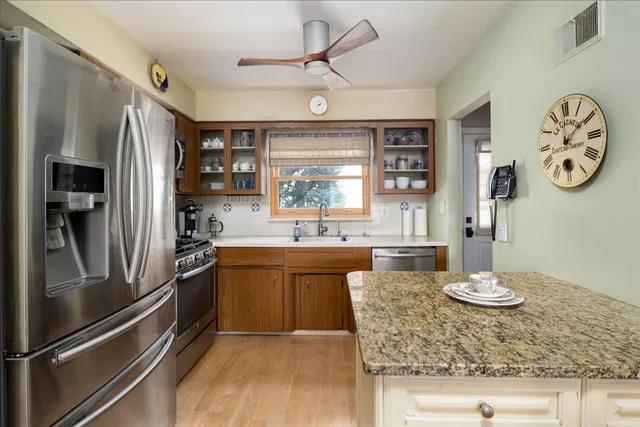 a kitchen with stainless steel appliances granite countertop a refrigerator and a sink