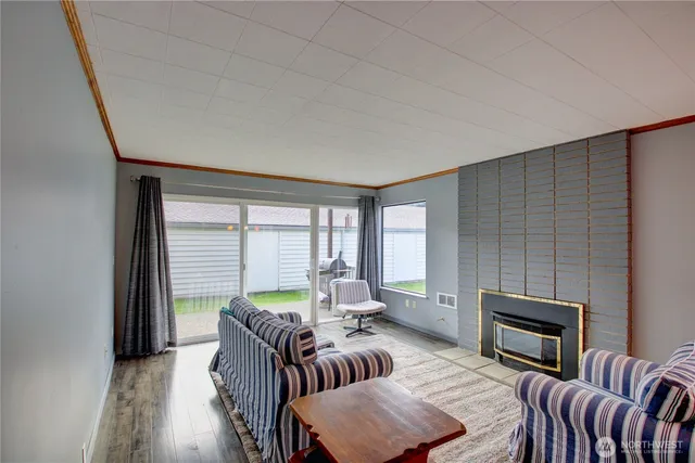 a living room with furniture a fireplace and a floor to ceiling window