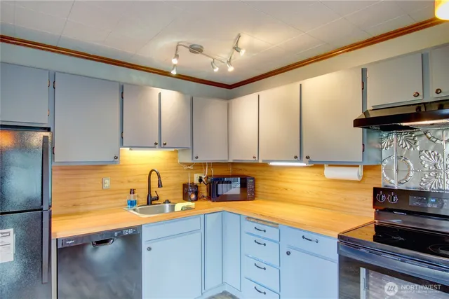 a kitchen with stainless steel appliances granite countertop a sink a stove and a refrigerator