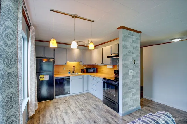 a kitchen view with granite countertop a sink and a refrigerator