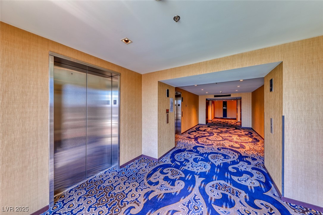 4381 West Flamingo Road, Unit 901 Las Vegas, NV 89103 - Photo 12 of 58 Hallway with elevator, wallpapered walls, and baseboards