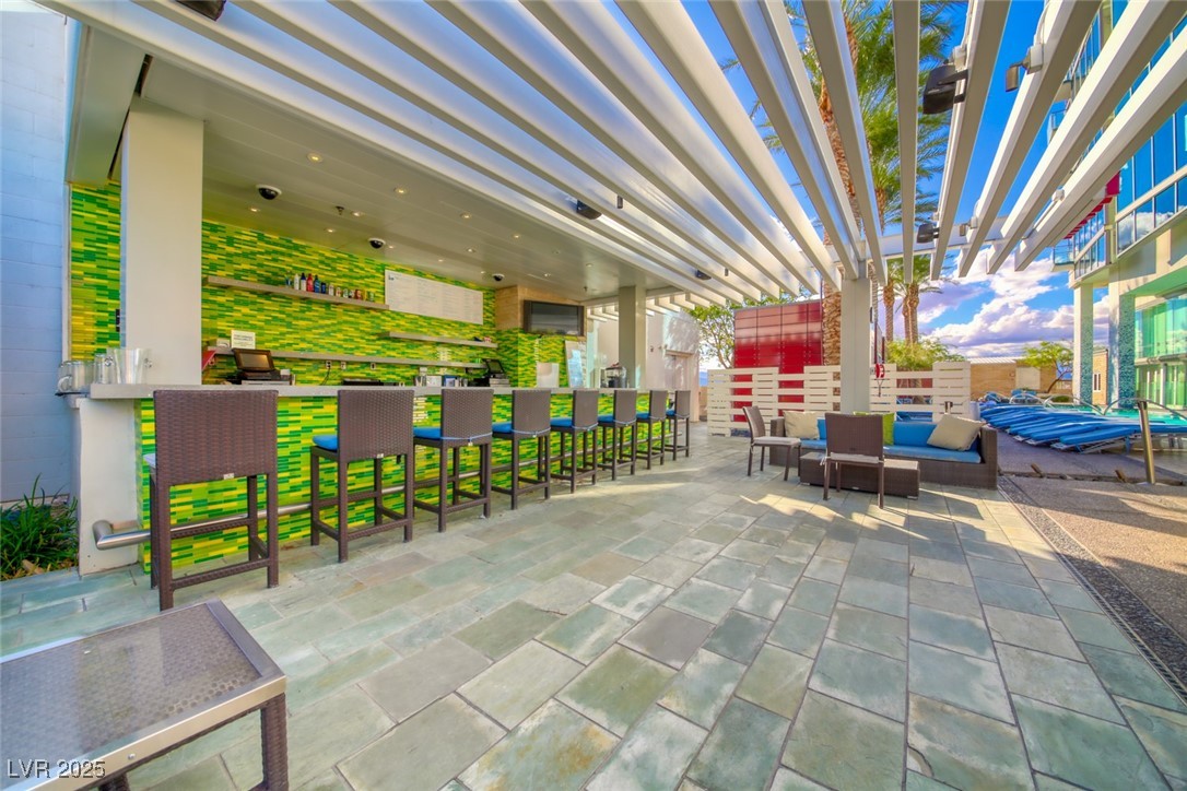 4381 West Flamingo Road, Unit 901 Las Vegas, NV 89103 - Photo 17 of 58 View of patio featuring a bar and a pergola