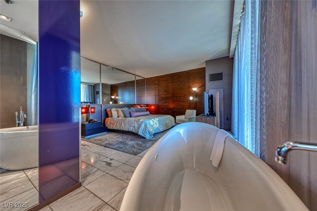 4381 West Flamingo Road, Unit 901 Las Vegas, NV 89103 - Photo 27 of 58 Bedroom featuring marble finish flooring and wooden walls