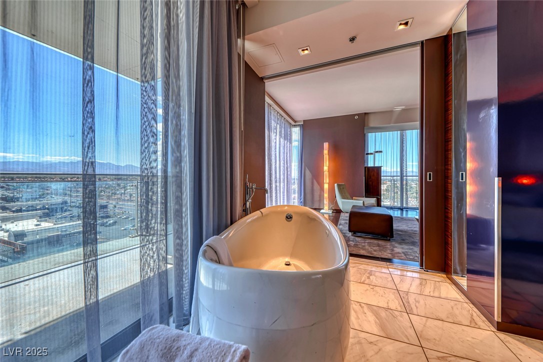 4381 West Flamingo Road, Unit 901 Las Vegas, NV 89103 - Photo 28 of 58 Bathroom with a soaking tub and marble finish flooring