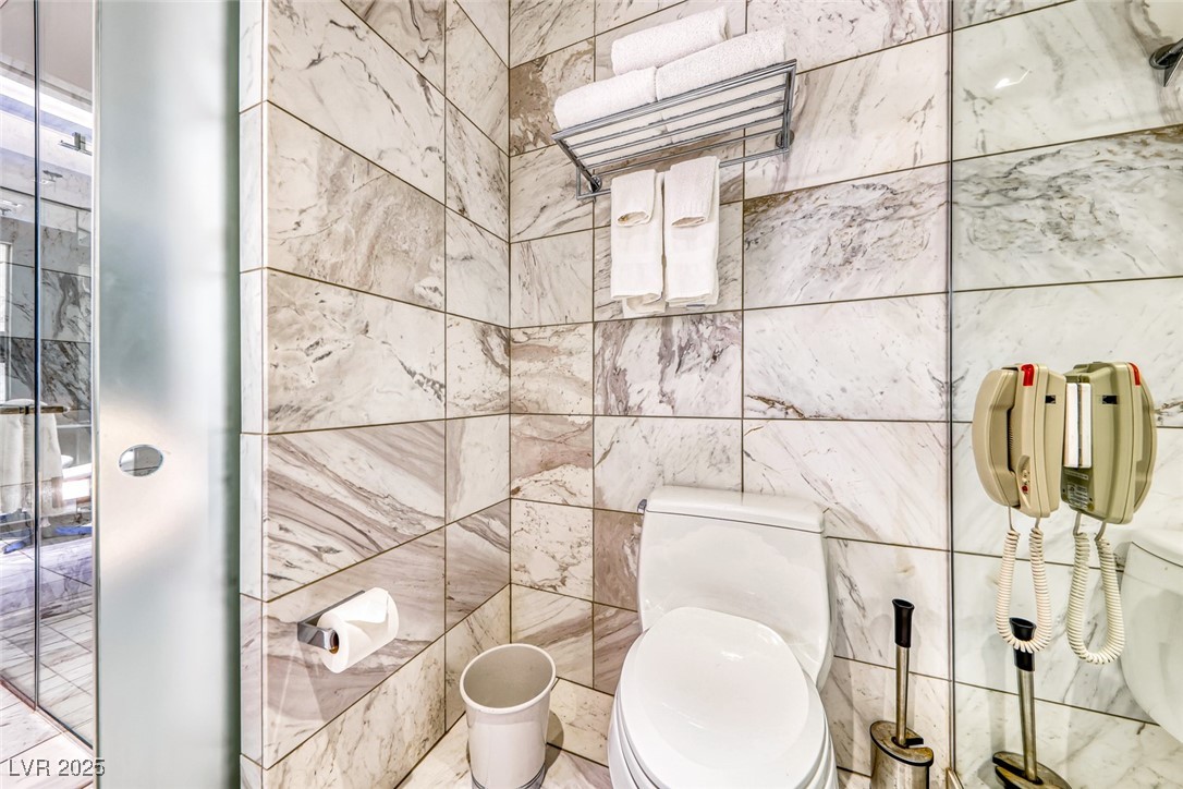 4381 West Flamingo Road, Unit 901 Las Vegas, NV 89103 - Photo 29 of 58 Bathroom with toilet and tile walls