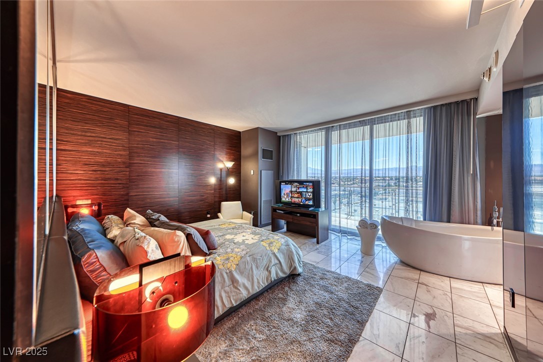 4381 West Flamingo Road, Unit 901 Las Vegas, NV 89103 - Photo 34 of 58 Bedroom with expansive windows and marble finish floors