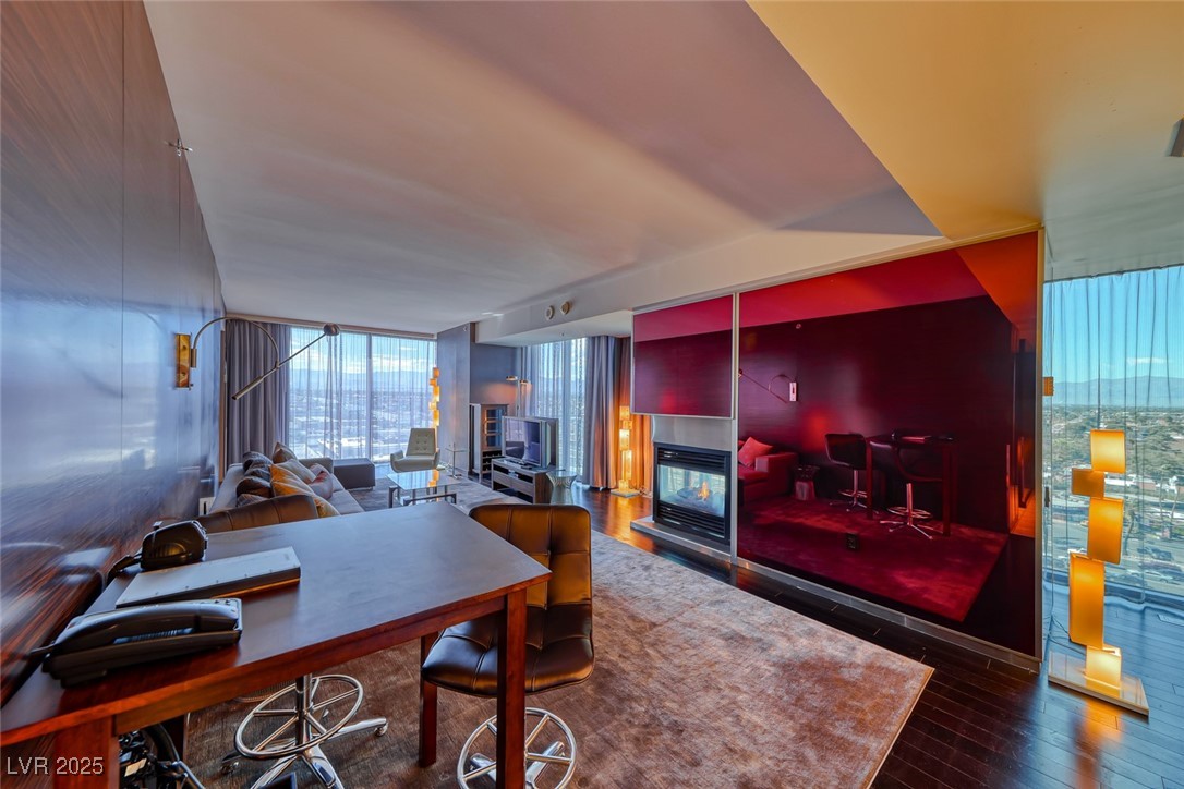 4381 West Flamingo Road, Unit 901 Las Vegas, NV 89103 - Photo 36 of 58 Office space featuring a wall of windows, hardwood / wood-style flooring, and a multi sided fireplace