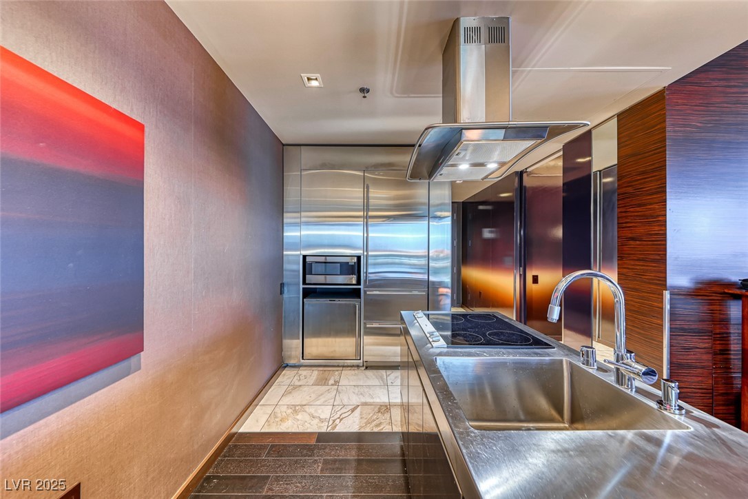 4381 West Flamingo Road, Unit 901 Las Vegas, NV 89103 - Photo 5 of 58 Kitchen featuring stainless steel countertops, a sink, island exhaust hood, appliances with stainless steel finishes, and a textured wall