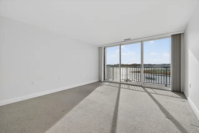 a view of a room with wooden floor and a ceiling fan