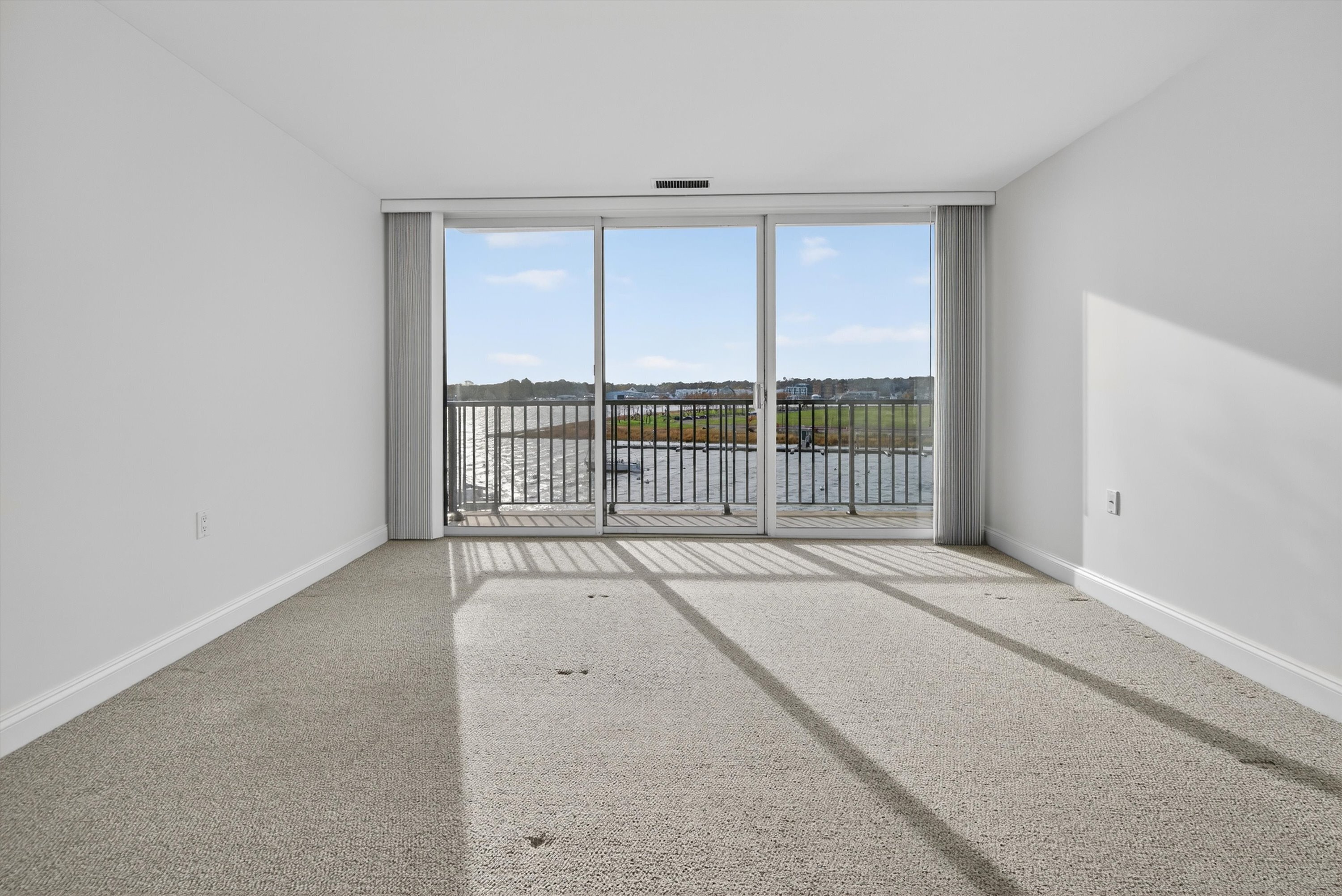 100 Seaview Avenue, Unit 3I Norwalk, CT 06855 - Photo 18 of 40 an empty room with wooden floor and windows