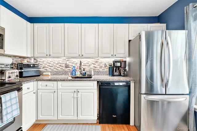 a kitchen with granite countertop a refrigerator sink and cabinets