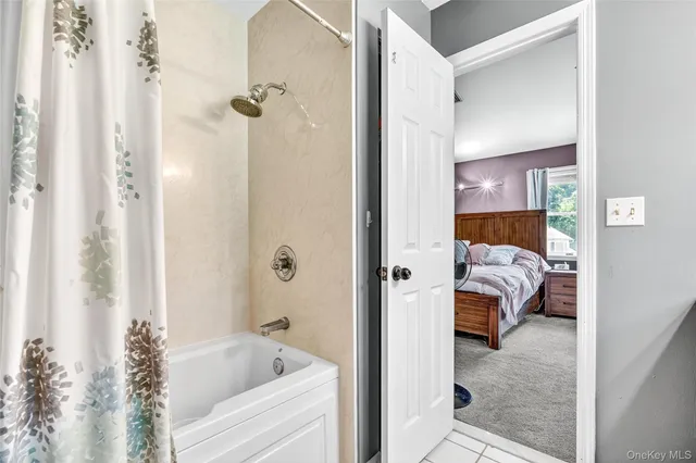 a en suite bathroom with a tub shower and bedroom view