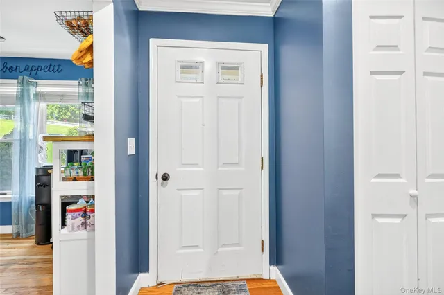 a view of a hallway with wooden floor and front door