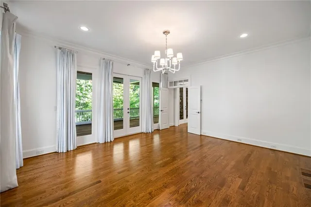 a view of a livingroom with a chandelier wooden floor and chandelier