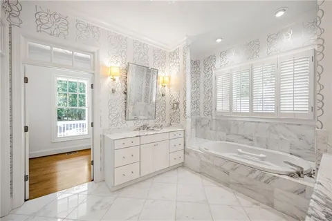 a spacious bathroom with a tub sink shower and mirror