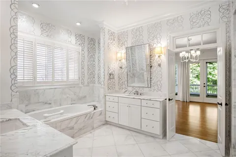 a spacious bathroom with a tub sink shower and mirror