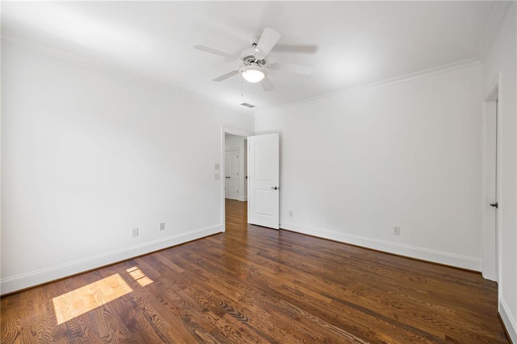9179 Selborne Lane Chattahoochee Hills, GA 30268 - Photo 25 of 53 an empty room with wooden floor and fan