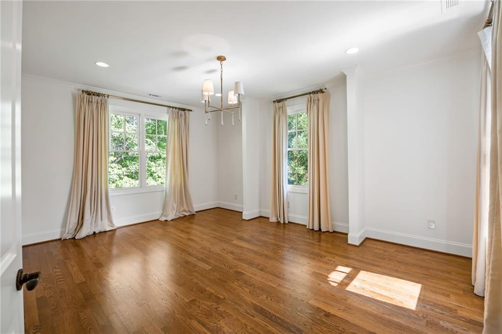 9179 Selborne Lane Chattahoochee Hills, GA 30268 - Photo 27 of 53 an empty room with wooden floor fireplace and windows