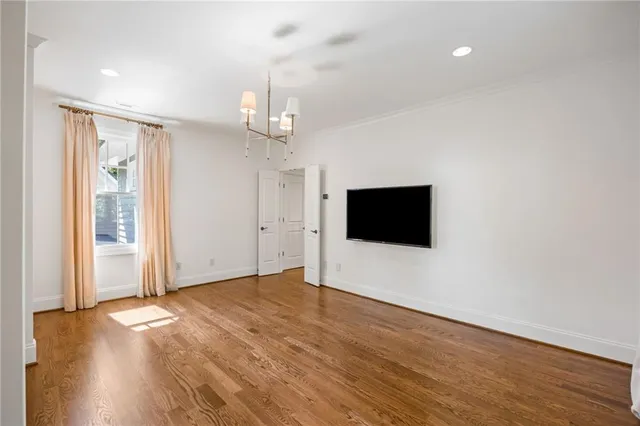 a view of a livingroom with wooden floor and a flat screen tv