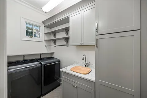 a utility room with sink dryer and washer