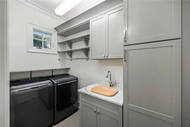 a utility room with sink dryer and washer