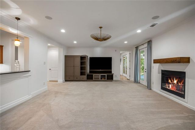 a view of an empty room with a fireplace and a window