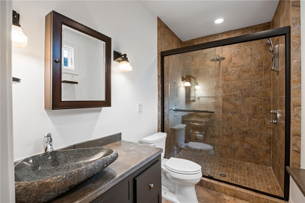 9179 Selborne Lane Chattahoochee Hills, GA 30268 - Photo 36 of 53 a bathroom with a granite countertop sink toilet and shower