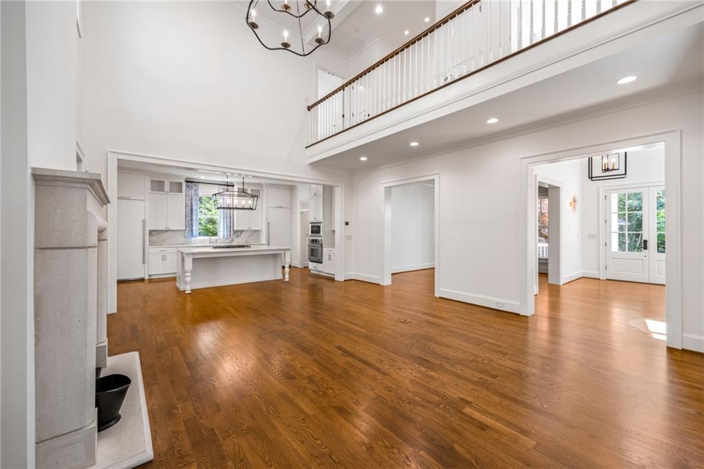 9179 Selborne Lane Chattahoochee Hills, GA 30268 - Photo 7 of 53 a view of empty room with wooden floor and kitchen view