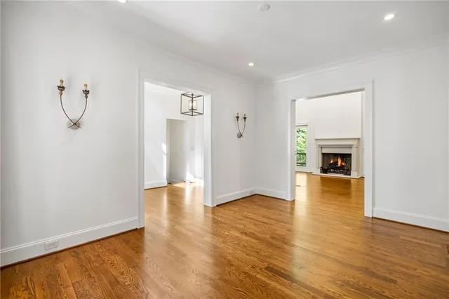 a view of empty room with wooden floor and fireplace