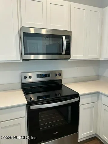 a view of kitchen with refrigerator microwave and stove