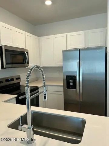 a view of a kitchen with wooden floor and sink