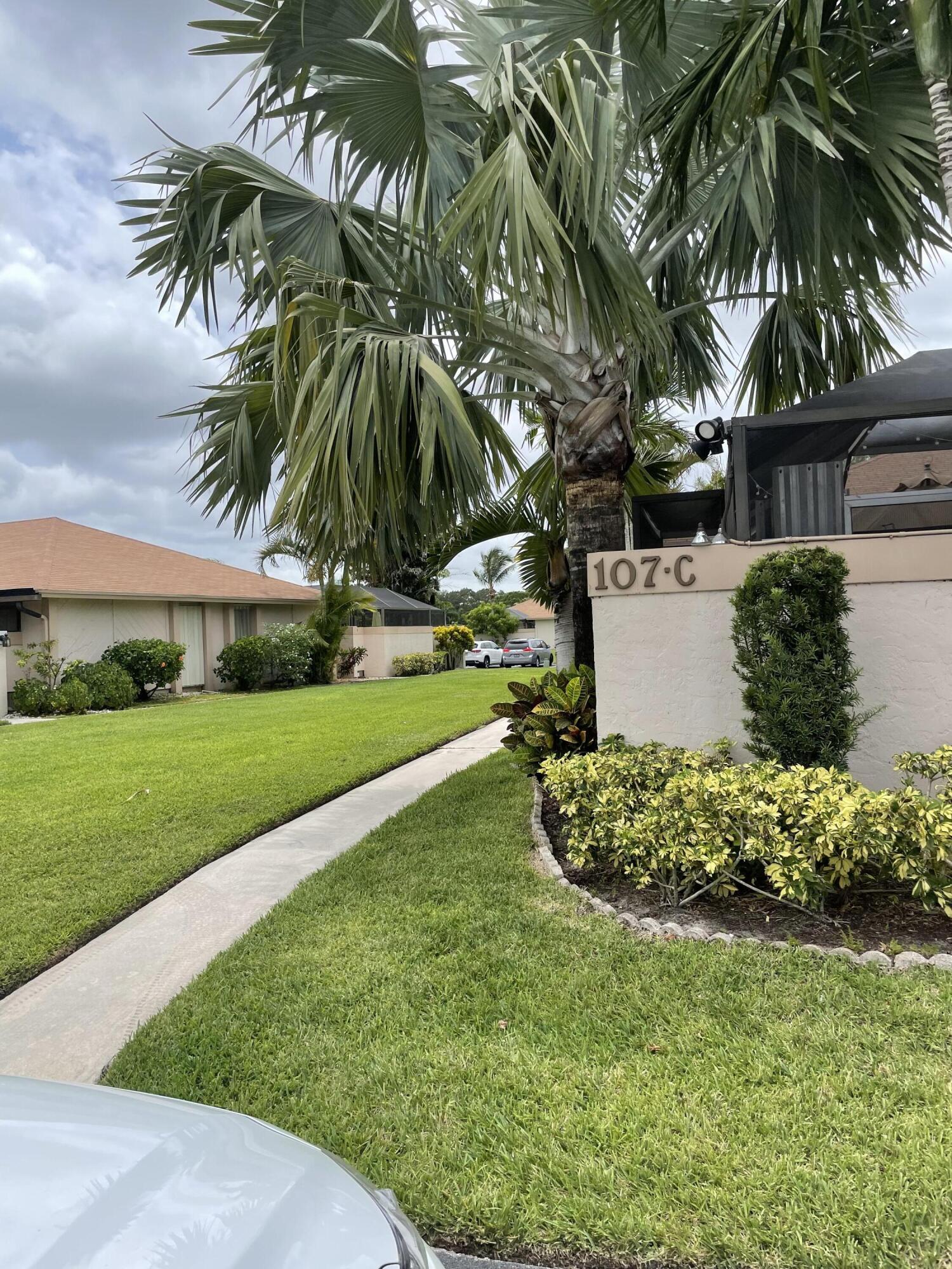 107 Bent Arrow Drive, Unit D Jupiter, FL 33458 - Photo 4 of 15 a view of a yard with palm trees
