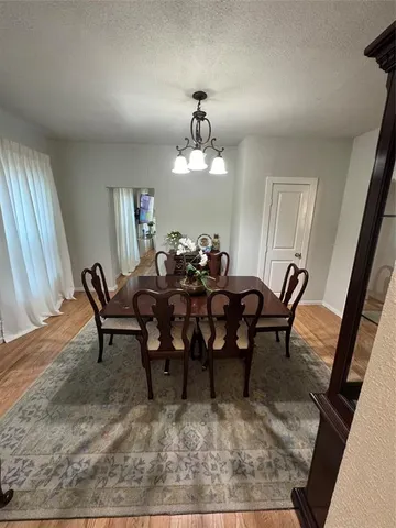 a view of a a dining room with furniture window and wooden floor