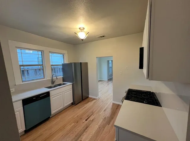 a kitchen with stainless steel appliances a stove a sink and a refrigerator