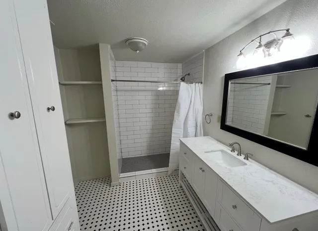 a bathroom with a double vanity sink toilet and shower