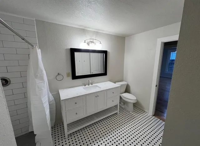 a bathroom with a toilet a sink and mirror