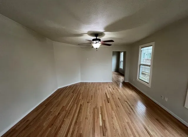 wooden floor in an empty room with a window