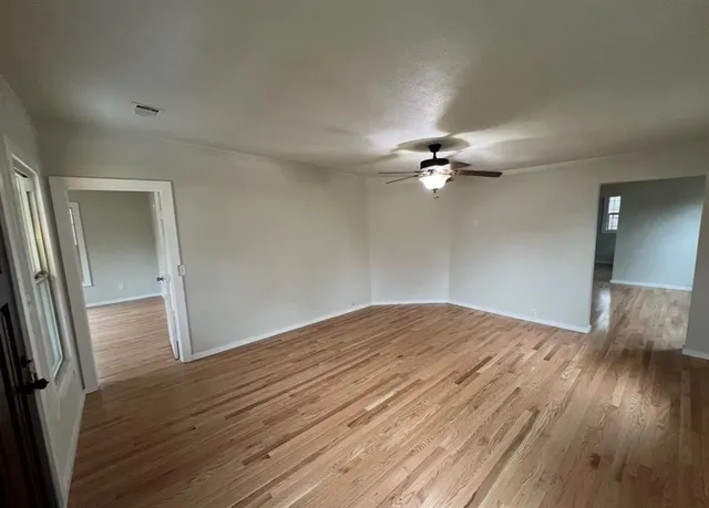 a view of a livingroom with a ceiling fan and wooden floor