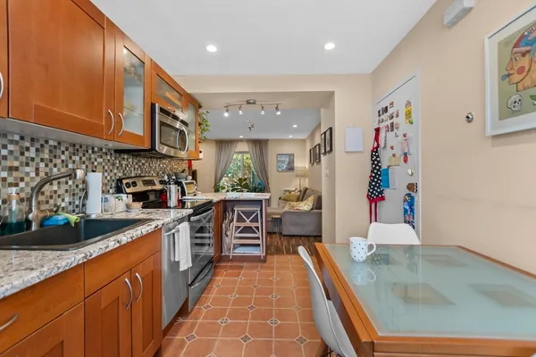 a large kitchen with stainless steel appliances granite countertop a sink and cabinets